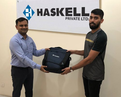 Two Singapore office employees showing off a Haskell backpack